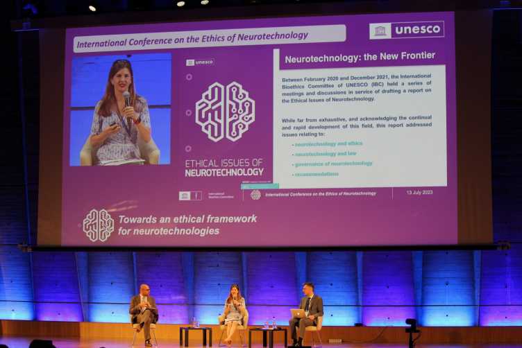 Prof. Emily Cross speaking on stage at the UNESCO International Conference on Ethics of Neurotechnology.